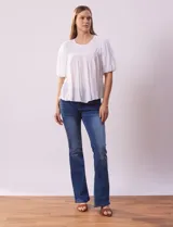 Blusa celeste de gasa marca Zac & Rachel, con cuello redondo, frunces en el frente, mangas 3/4 con puño, abertura central en la espalda y botón.