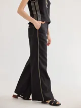 Pantalón negro de lino, de corte palazzo, con bolsillos laterales y vivos a contratono color beige.