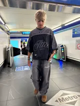 Pantalón de jean gris oscuro con corte amplio y estampado con el logo de la marca en la pierna izquierda.