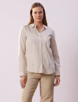 Camisa a rayas verticales finas color beige y blanco, marca Alex & Jordan. Tiene cuello con solapa, abertura central con botones y bolsillo aplicado en el pecho.