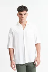 Camisa blanca de manga corta, corte oversize y cuello clásico.