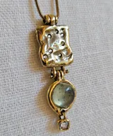 Collar dorado con cadena fina y dije con forma irregular con incrustaciones y dije colgante con piedra prehnita redonda y dije cuadrado pequeño. 