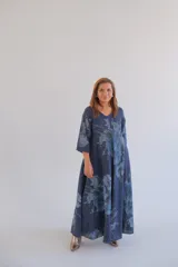 Vestido largo de lino color azul con estampado floral, corte amplio, mangas 3/4 y cuello en V.