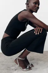 Sandalia plateada de tacón fino con efecto metalizado craquelado. Tiene tira ancha en la parte delantera, cierre con hebilla metálica en la pulsera del tobillo y punta cuadrada.