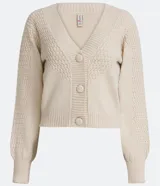Cardigan corto de punto color crema, con escote en V, abotonadura frontal y mangas largas abullonadas con puños acanalados. Presenta un punto calado en forma de rombos en la parte superior del busto y en las mangas.