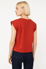 Remera blanca de algodón con cuello redondo y mangas cortas con hombreras.