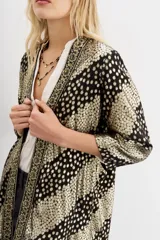 Kimono de viscosa con jacquard en lurex, calce recto y mangas largas. Presenta guarda bordada en el frente con apliques e interior en jacquard.