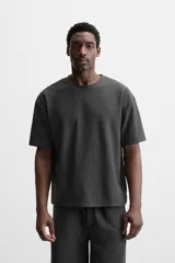 Camiseta negra de corte holgado, con cuello redondo y mangas cortas.