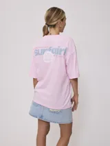 Remera color crudo con estampado frontal y trasero con la leyenda "Surf Girl Rusty". Corte oversize y confeccionada en algodón.