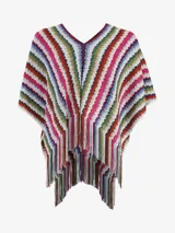 Poncho de punto multicolor con diseño de rayas verticales en zigzag y flecos en el borde inferior.