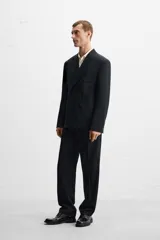 Blazer straight fit confeccionada en tejido de lana de origen italiano. Cuello con solapas de pico y manga larga acabada en puño con botones. Bolsillos de plastrón en pecho y cadera. Detalle de bolsillo interior. Bajo con aberturas en espalda. Cierre frontal de botonadura cruzada.