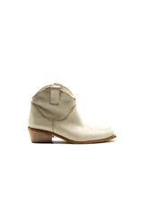 Botas de caña baja color crema, estilo texanas, con bordados a tono en la puntera y caña. Cuentan con un tacón bajo y punta alargada redondeada con suela cuadrada de terminación lisa que sobresale levemente.