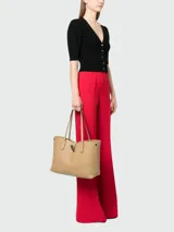 Cartera tote de cuero flexible en color beige, con diseño elegante y logo de la marca.