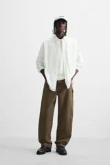 Pantalón color verde oliva de corte recto, confeccionado en algodón. Cuenta con bolsillos frontales, traseros y laterales tipo cargo, además de una tira multifunción.