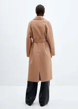 Abrigo largo color camel de lana reciclada con diseño oversize, cuello con solapa, manga larga, dos bolsillos delanteros, cinturón desmontable y abertura posterior en el bajo.