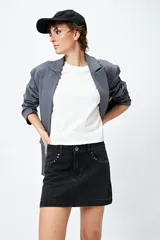Minifalda de jean celeste con tiro bajo y detalle de tachas metálicas en los bolsillos.