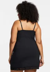 Chemise negro con breteles finos y detalles de encaje en el escote y ruedo.