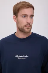 Camiseta azul marino de manga larga y cuello redondo con estampado frontal con la leyenda "Originals Studio BROUGHT TO YOU BY JACK & JONES® DESIGNED IN COPENHAGEN".