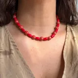 Collar corto de cuentas rojas con detalles en dorado.