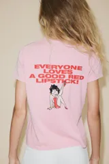 Camiseta rosa de manga corta y cuello redondo con estampado de Betty Boop y texto "I feel pretty in red". Debido al proceso de tintado y lavado, el color de cada prenda es único y especial por lo que puede presentar diferencias con respecto al mostrado en la foto.
