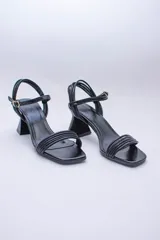 Sandalias negras de tiras finas con taco geométrico.