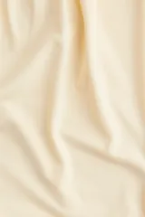 Top cropped color crema, sin mangas, de punto suave con costuras fruncidas para una silueta abullonada con efecto drapeado.