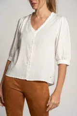 Blusa blanca de viscosa con escote en V, mangas 3/4 abullonadas y detalle de plumeti.