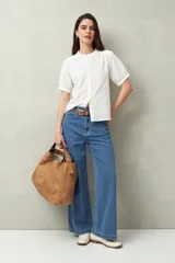 Camisa blanca de manga corta abullonada, cuello mao y botones forrados.