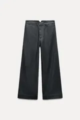 Pantalón de jean azul oscuro, de tiro medio, corte wide leg y bolsillos laterales.