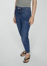 Jeans mom-fit de tiro alto, color azul denim, con cinco bolsillos y cierre de cremallera y botón.