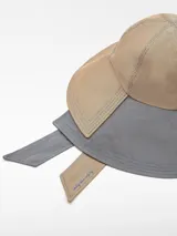 Sombrero de ala ancha bicolor con rayas verticales, confeccionado en poliéster y algodón. Presenta tiras anchas para atar con logo bordado.