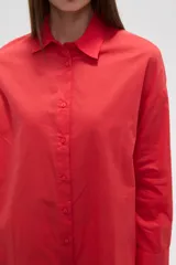 Camisa blanca de algodón con cuello clásico, corte holgado, cierre frontal con botones y mangas largas.