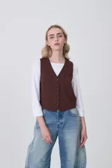 Chaleco de vestir color marrón oscuro, con escote en V y cierre frontal de botones.