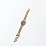 Reloj digital dorado con malla metálica.