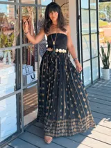 Falda larga negra con estampado dorado, cintura elástica y corte amplio.