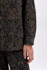 Camisa de manga larga, corte oversize, con cuello camisero y botones frontales. Estampado de patrón orgánico en color dorado sobre fondo negro.