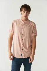 Camisa lisa color salmón con cuello mao y mangas cortas con dobladillo.