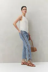 Top sin mangas color blanco, confeccionado en tejido liviano con textura sutil y líneas verticales.