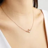 Collar dorado con cadena fina y dije de tres estrellas con incrustaciones de strass.