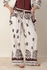 Pantalón palazzo de lino y viscosa color crudo con estampado de hojas en marrón chocolate.