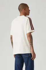 Remera color crema de corte holgado con mangas raglán y rayas marrones en los hombros. Estampado frontal con el logo de Levi Strauss & Co. y el año de fundación (1873).
