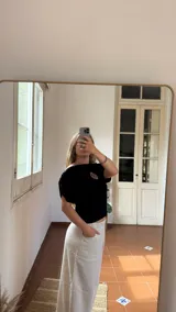 Remera negra de algodón con cuello bote y escudo de Uruguay bordado en dorado.