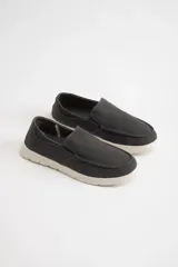 Mocasines náuticos grises de lona con suela blanca.