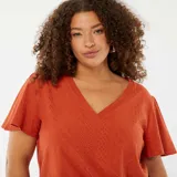 Camiseta color ladrillo de punto calado con escote en V y mangas cortas tipo murciélago.
