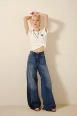 Pantalón de jean de tiro alto, corte wide leg, con diseño de parches en diferentes tonos de azul.