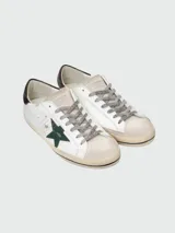 Championes Golden Goose modelo Super-Star, de cuero blanco con estrella verde y talón con estampado animal print.