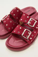 Sandalia tipo birkenstock de color negro, con dos tiras ajustables con hebillas metálicas plateadas. Las tiras están decoradas con tachas plateadas.