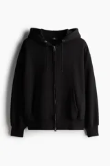 Campera con capucha negra, corte oversized, con cierre frontal, bolsillos y puños acanalados.