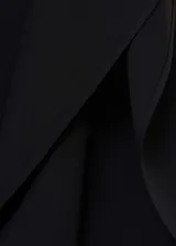 Vestido corto negro con diseño evasé y mangas asimétricas.