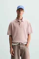 Polo de hombre color rosa, corte relaxed fit, tejido de punto con textura bouclé y mezcla de algodón. Tiene cuello solapa, cierre frontal con botones, manga corta y acabados en rib.